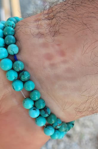 Gros plan sur le bracelet Turquoise Arizona d'un client, qui paraît serré sur le poignet.