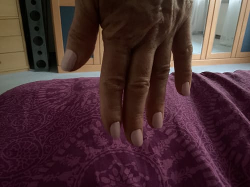 Eine Kundin zeigt ihre Hand mit den aufgetragenen, dezenten UV Gel Nagelfolien im Farbton Rosé Teint.