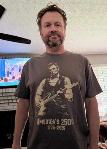 Customer wearing the grey Lincoln 250 T-Shirt, showing the graphic of Lincoln with a guitar.