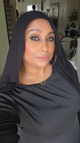 Customer wearing a plain black head covering and satin top in a selfie for a Shipping Protection review.