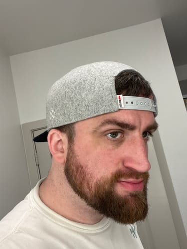Reviewer wearing the grey Big Flat Bill Structured Wool Hat backwards, showing the double-snap closure.