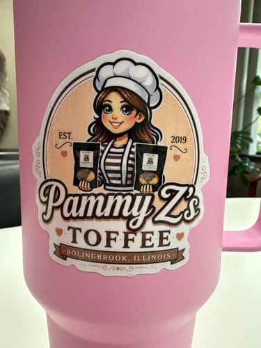 Customer's custom vinyl sticker with a logo design applied to the side of a pink travel mug.
