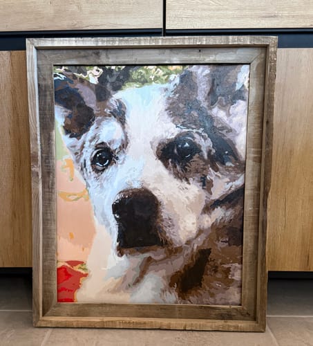 Customer's completed Custom Paint by Numbers Kit, a lifelike portrait of a dog in a rustic wooden frame.
