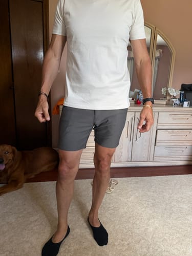Customer wearing the charcoal Ultra-Stretch 7" Chino Shorts with a white t-shirt in a bedroom.