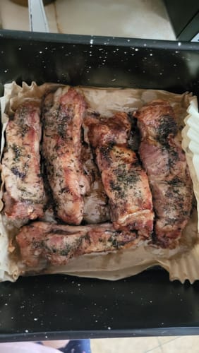 Recenzentul prezintă coaste de porc rumenite și suculente gătite în cuva friteuzei Air Fryer Novio StonePro.