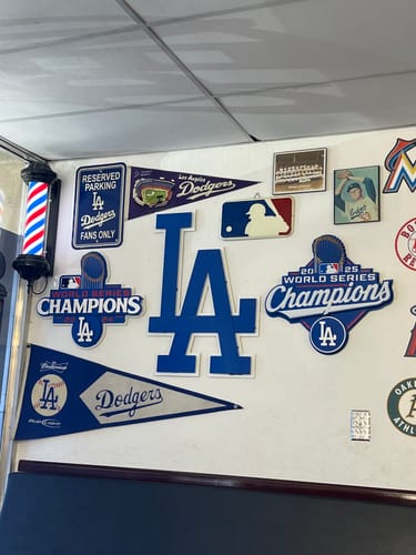 Customer's Los Angeles Dodgers LA metal wall art mounted on a barbershop wall with other fan memorabilia.