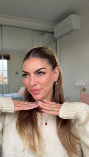 Reviewer wearing long, full Infinaluxe Pre-Glued Lash Extensions while smiling.