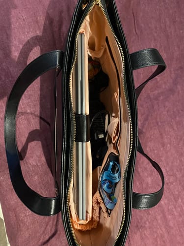 Customer's open black The One Tote viewed from above, with a laptop and other items fitting inside the blush interior.