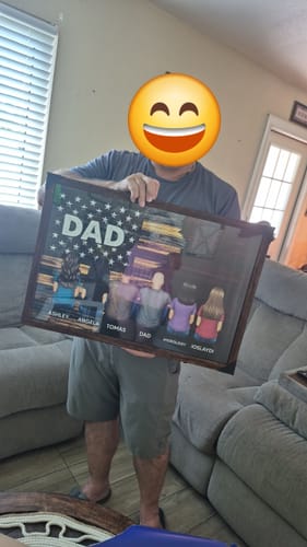A customer holding their framed personalized poster, which shows illustrated figures from behind with names under a flag design.