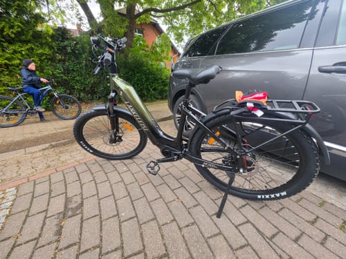 Customer's Lankeleisi MG600 Lite e-bike parked on a kickstand on a paved residential street.