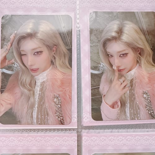 Customer shows two XLOV "I,God" official photocards of a blonde person in different poses, held in a pink binder sleeve.