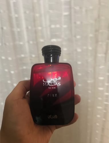 Cliente sosteniendo un frasco de perfume rojo y negro que fue protegido durante el envío.