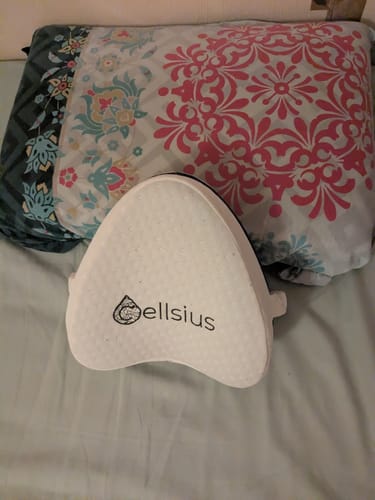 Photo d'un client montrant le petit coussin d'alignement blanc sur un lit.