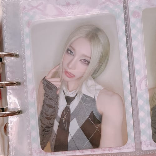 Customer's XLOV "I,God" fansign photocard featuring a person with light hair, held in a binder sleeve.