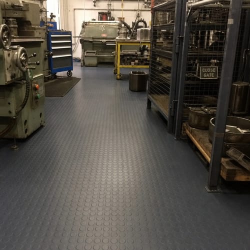 Customer's Studded Dot Rubber Flooring installed in a busy industrial workshop aisle.
