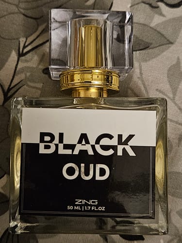 Customer's bottle of Black Oud fragrance, a clear rectangular bottle with a gold cap and a black and white label.
