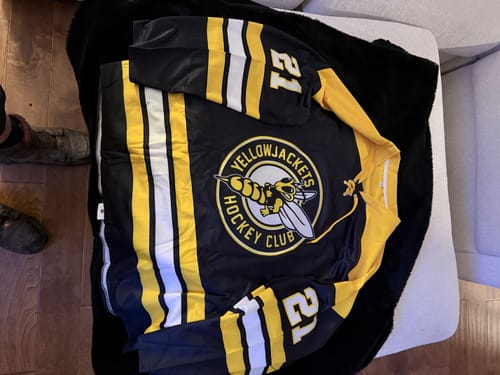 Customer's black and gold custom hockey jersey with a 'Yellowjackets Hockey Club' logo and the number '21' on the sleeve.