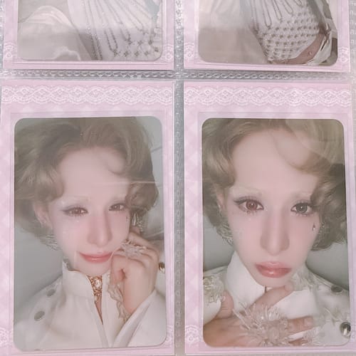 Customer's XLOV 'I,God' Official Photocards displayed in a pink binder sleeve.