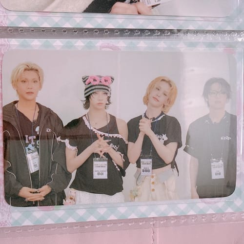 Customer's group photocard from the 'EgoZgo x XLOV' pack showing four members, placed in a decorative binder sleeve.