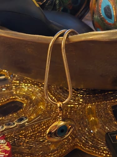 Customer's gold Round Snake Chain with a large, eye-shaped pendant attached.