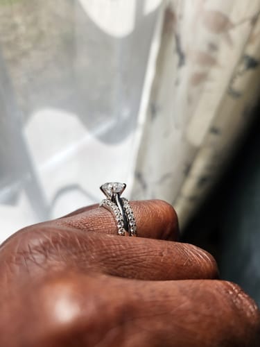 Customer's hand showing a side profile of the semi mount ring paired with a sparkling pavé band.