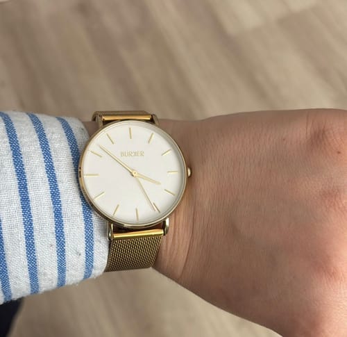 Customer's wrist wearing the sleek Ruby Gold White Mesh watch with its white face and gold band.