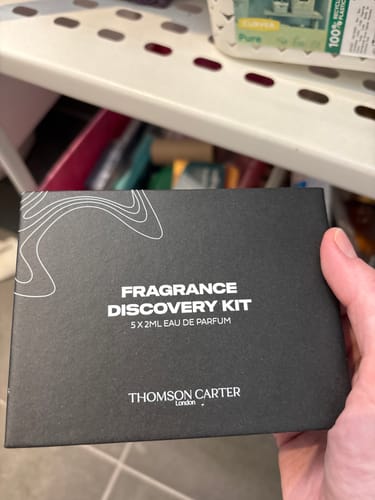 Customer holding the black Thomson Carter Fragrance Discovery Kit box.