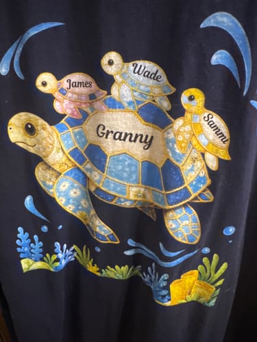 Customer's personalized t-shirt showing a large 'Granny' turtle with three smaller turtles on its back, including a pink one named 'James'.