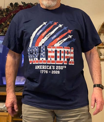 A customer wearing the navy personalized 'Grandpa' shirt with the 250th anniversary flag design.