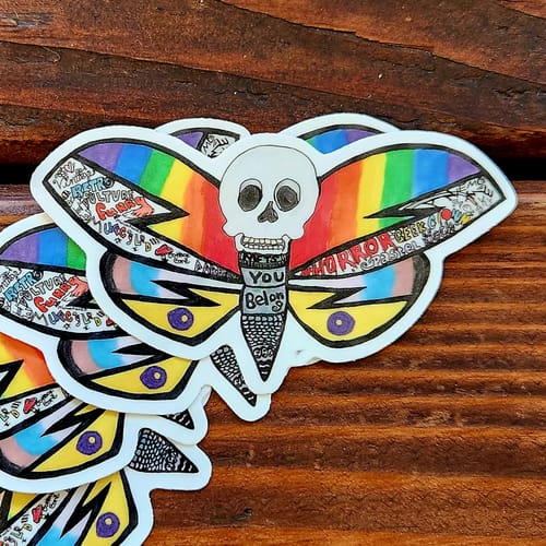Customer's stack of custom vinyl stickers showing a colorful moth design with a skull head.