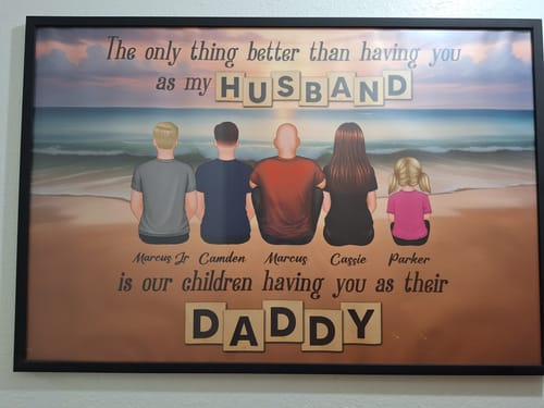 Customer's framed personalized poster showing an illustrated family of five sitting on a beach, with a loving message.