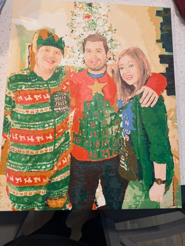 Reviewer's completed painting from the Custom Paint by Numbers Kit, showing a family in festive Christmas sweaters.
