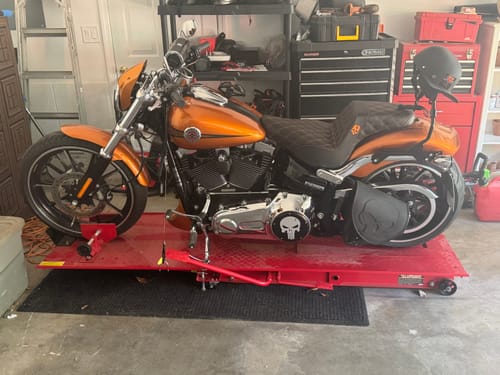 Customer's orange Harley-Davidson motorcycle with a new black Born Scum X Saddlemen Step Up Seat installed.