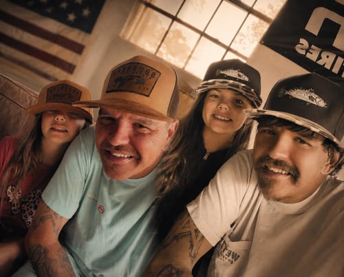 Customer and family wearing two different pairs of matching hats from the Hat of the Month Crew.