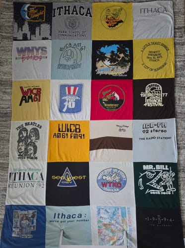 Customer's finished Project Repat T-Shirt Quilt, a colorful grid of vintage t-shirts featuring Ithaca and radio station logos.