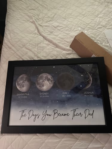 Customer's framed Starry Night poster showing four personalized birth moon phases on a bed.