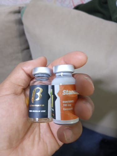 Primer plano de la mano de un cliente sosteniendo dos viales para su reseña del Supertest Omega Labs.
