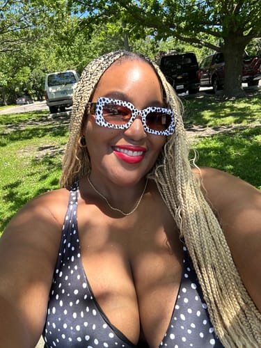 Reviewer smiling outdoors in a park, wearing the Spot Me If You Can Mixed Print Sunglasses.