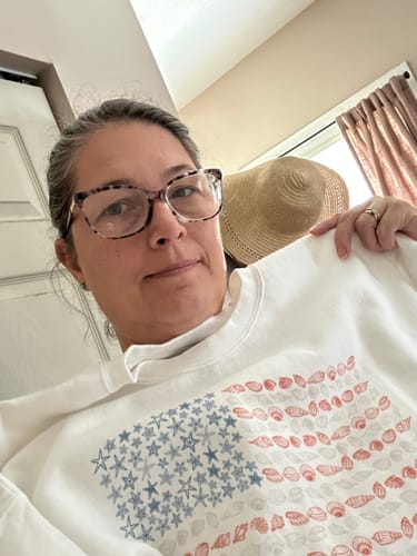 Customer wearing the white Seashell + Starfish Flag sweatshirt in a selfie.