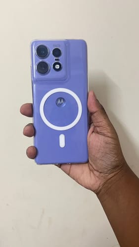 Reviewer holding a purple Motorola Edge 50 Pro with the clear Magsafe case, showing the white magnetic ring.