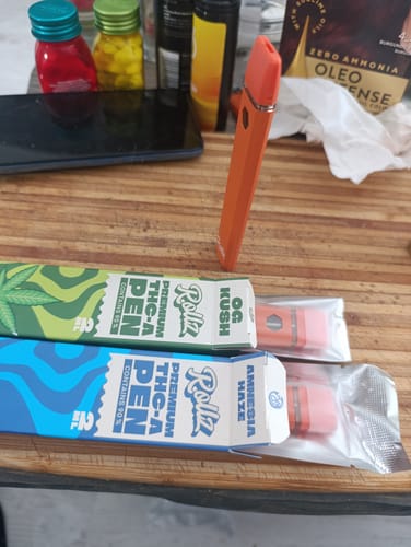 Reviewer's ROLLZ THCA Vapes in OG Kush and Amnesia Haze strains, with one vape standing next to the open boxes.