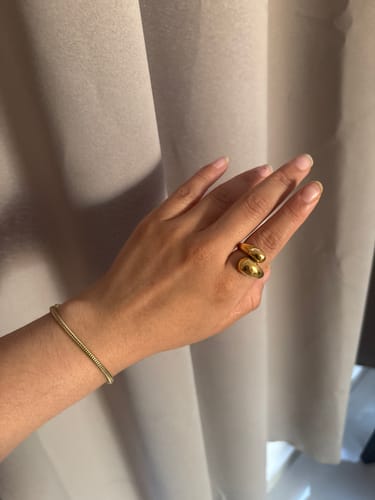 Cliente mostrando el Anillo Amelia Chunky, un anillo dorado y grueso, en la mano.
