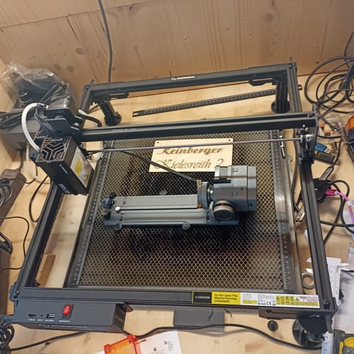 Customer's AtomStack A20 Pro V2 laser engraver set up with a rotary attachment and a finished wood engraving.