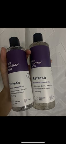 Customer holding an 8 oz and a 16 oz bottle of Refresh Plant Based Intimate Body Wash.