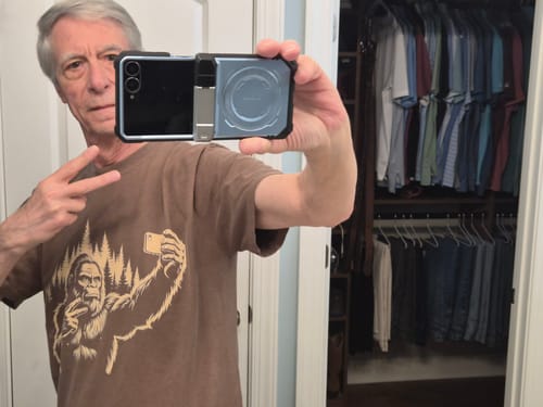 Customer takes a mirror selfie while wearing the brown Bigfoot Selfie T-Shirt.