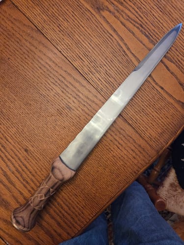 Customer's finished Scottish dirk, made with EdgeCore grinding belts, featuring a polished blade and carved wooden handle.