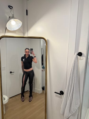 Customer taking a mirror selfie wearing the low-rise black Vice Pant, showing the lace-up side details.