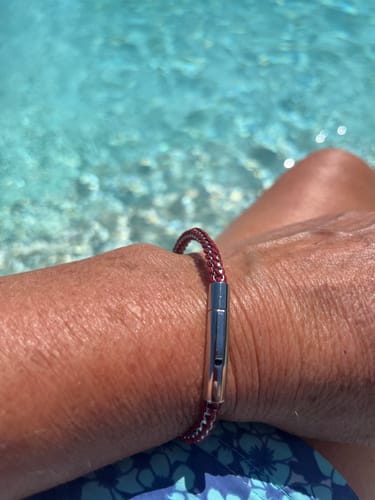 Customer wearing the red and steel Rope Box Link Bracelet on their wrist by a pool.