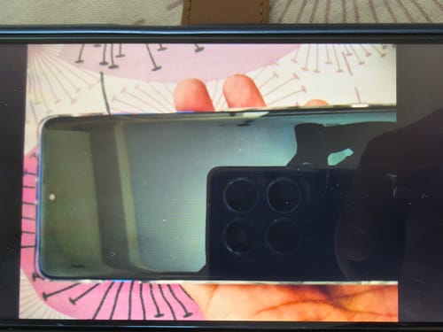 Customer's phone with the UltraShield Tempered Glass applied, showing a clear, reflective surface.