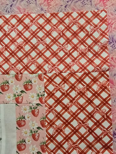 Reviewer's close-up of the Strawberry Fields Quilt Kit fabrics, highlighting the detailed, directional patterns.